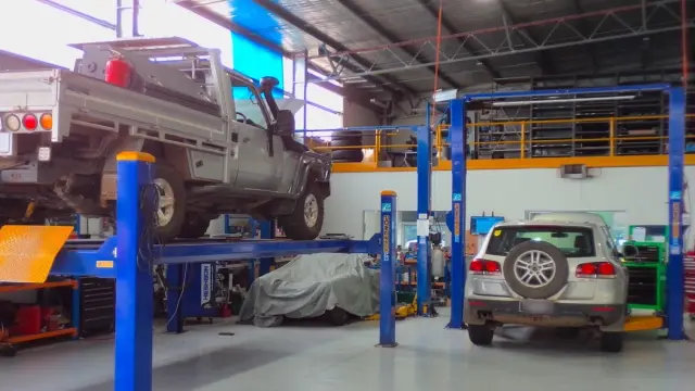 Interior of Bosch Car Service workshop with multiple cars undergoing repairs, showcasing the bustling environment of expert car servicing.